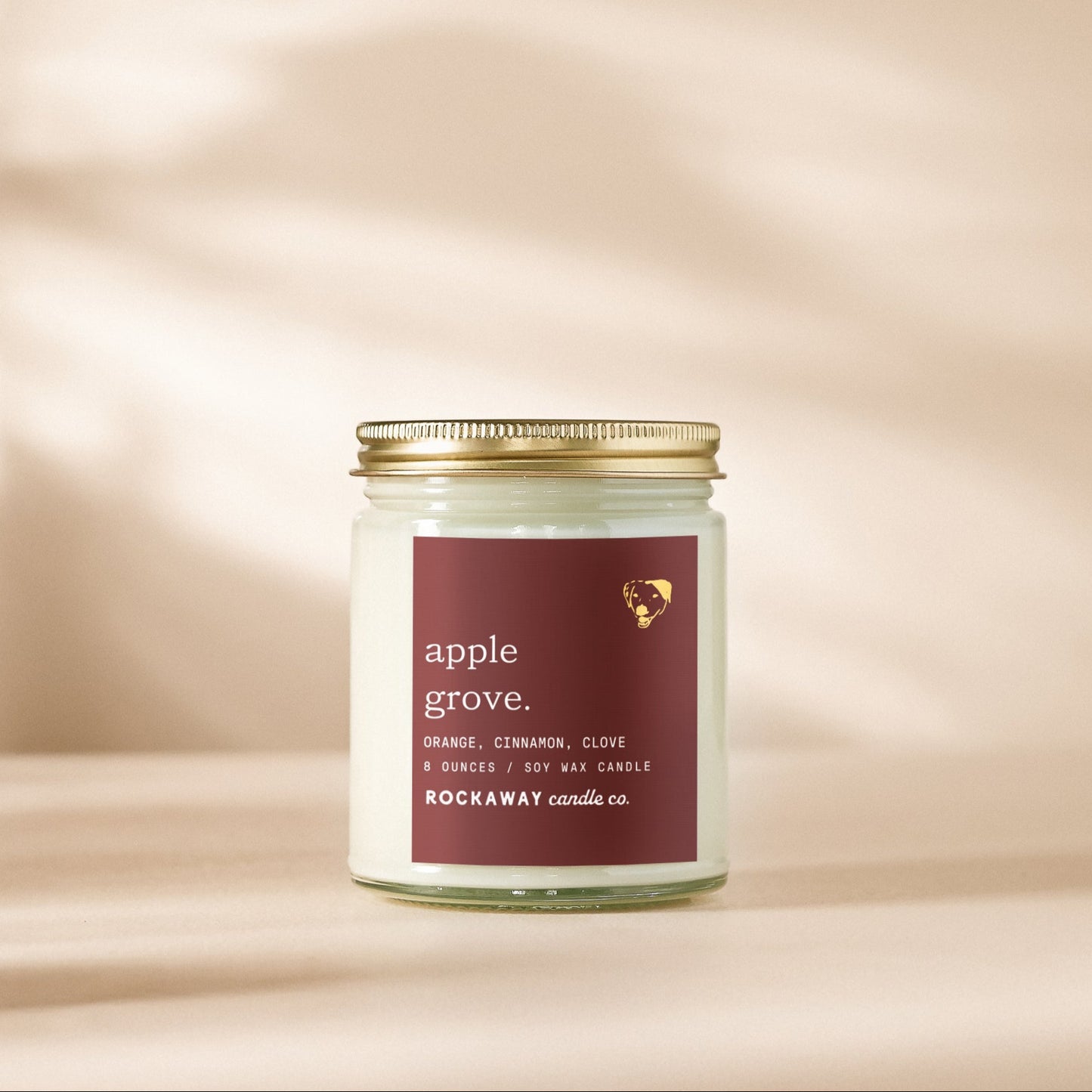 Candle jar labeled 'Apple Grove' on a beige background